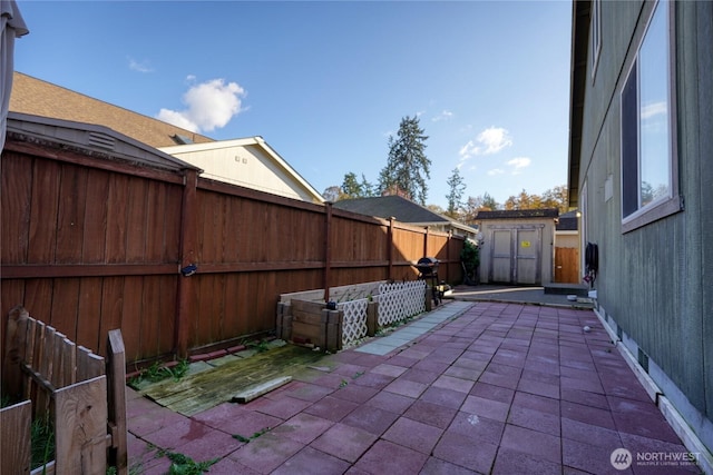 view of patio featuring an outdoor structure, a fenced backyard, and a shed