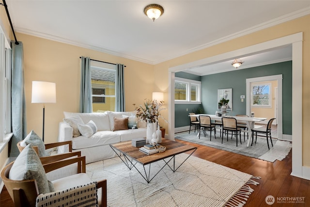 living room with a wealth of natural light, wood finished floors, and ornamental molding