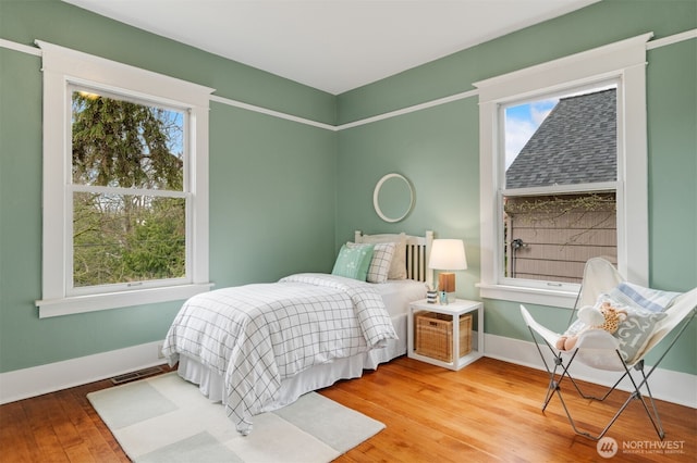 bedroom with visible vents, baseboards, and wood-type flooring