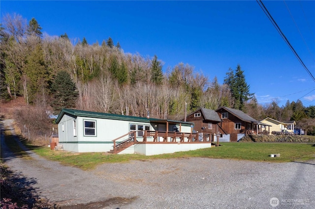 view of front of house featuring a wooden deck and a front lawn