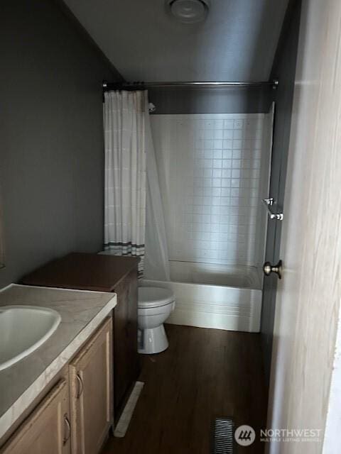 full bathroom with vanity, wood finished floors, visible vents, shower / bath combo with shower curtain, and toilet