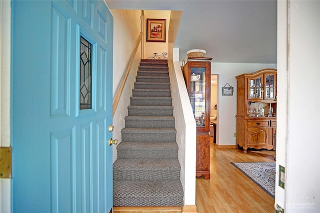 staircase with wood finished floors and baseboards