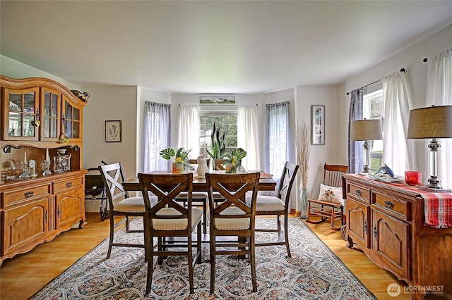 dining area with light wood-type flooring and baseboards