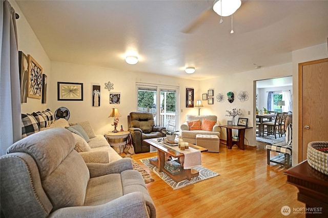 living room featuring light wood-type flooring and a ceiling fan