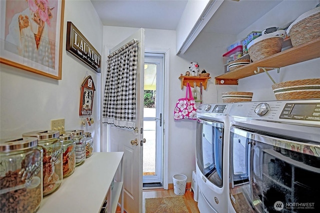 laundry room featuring washer and dryer, light wood-style floors, a healthy amount of sunlight, and laundry area