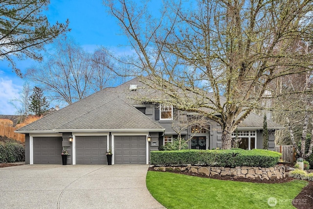 view of front of home with stucco siding, fence, concrete driveway, a front yard, and an attached garage