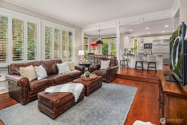 living area with crown molding, recessed lighting, and wood finished floors