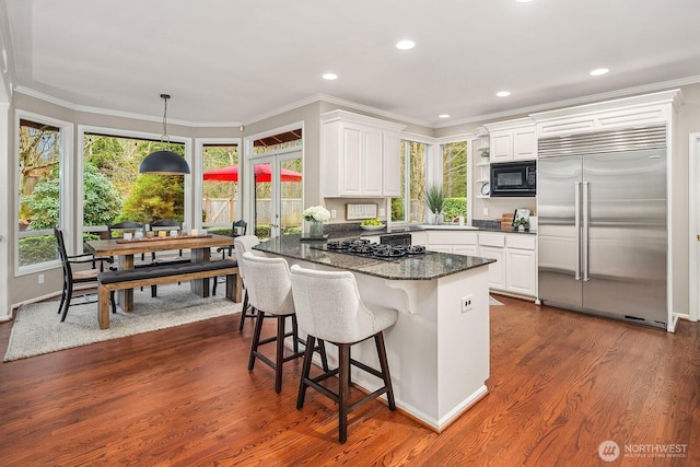 kitchen featuring black appliances, dark wood-type flooring, crown molding, a peninsula, and white cabinetry