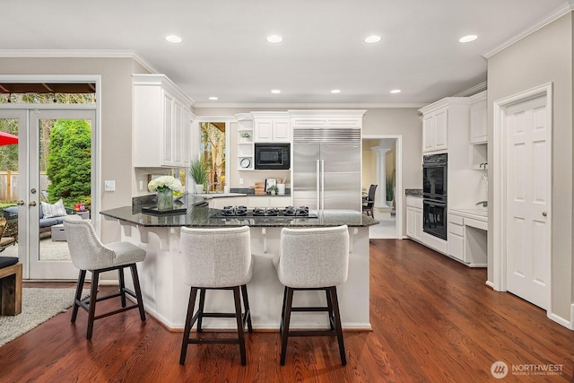 kitchen with black appliances, ornamental molding, dark wood finished floors, a peninsula, and white cabinets