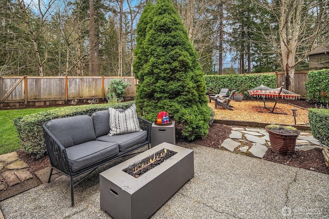 view of patio with an outdoor living space with a fire pit and a fenced backyard