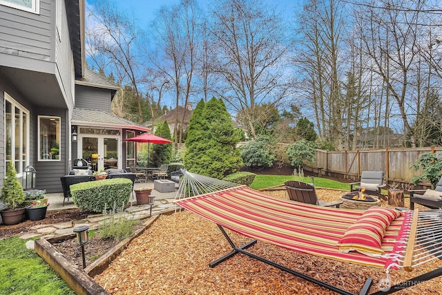 view of yard featuring french doors, a patio, fence, and an outdoor fire pit