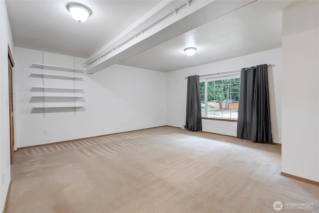 spare room featuring carpet flooring and baseboards