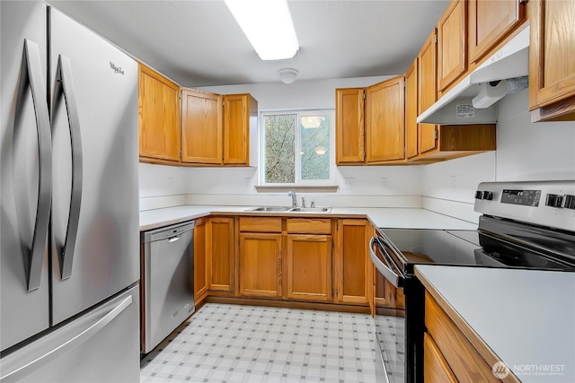 kitchen featuring under cabinet range hood, a sink, stainless steel appliances, light countertops, and light floors