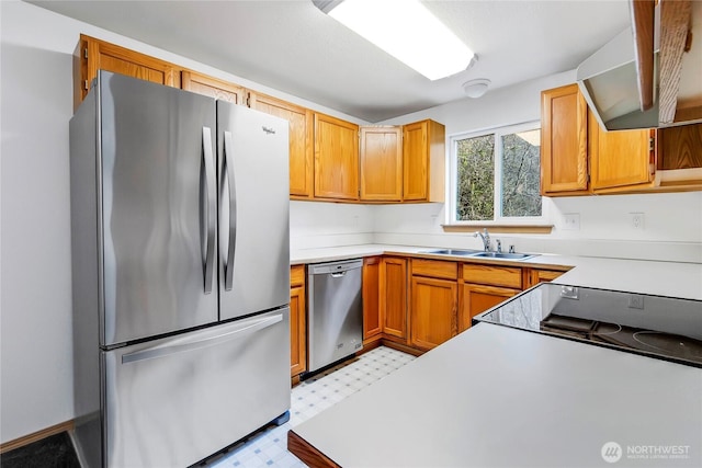 kitchen with light floors, appliances with stainless steel finishes, light countertops, and a sink