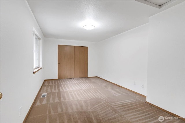 carpeted empty room featuring visible vents and baseboards