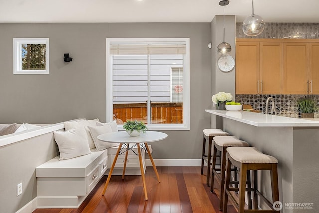 dining room featuring breakfast area, baseboards, and dark wood-style flooring