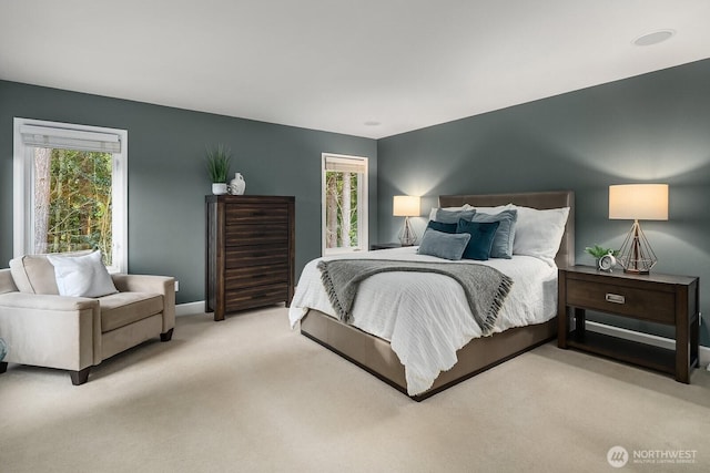 bedroom featuring light colored carpet and baseboards