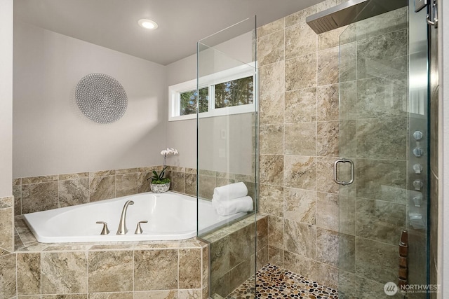 bathroom featuring a stall shower and a bath