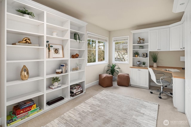 home office featuring light carpet and baseboards