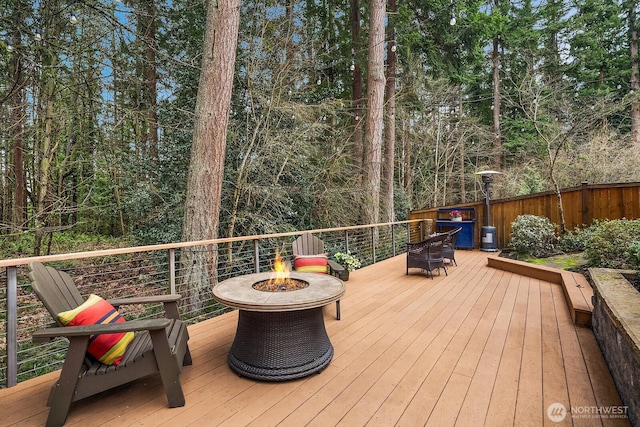 wooden terrace featuring fence and an outdoor fire pit