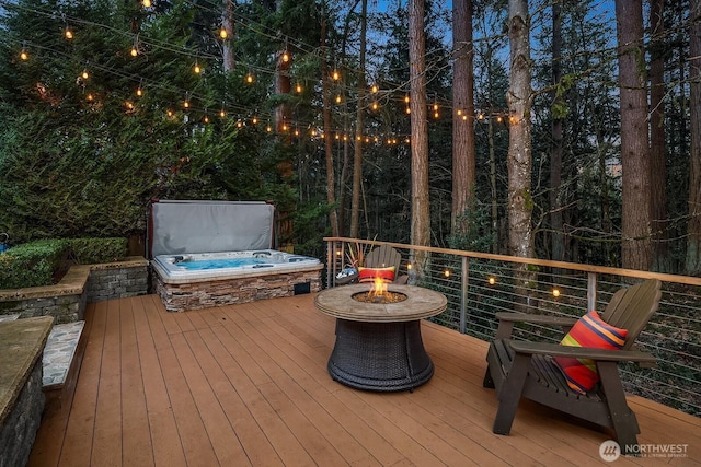 wooden terrace with a covered hot tub and an outdoor fire pit