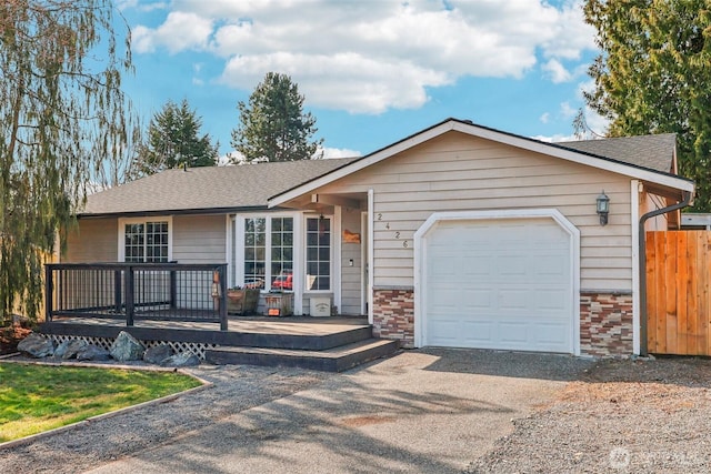 ranch-style house featuring brick siding, fence, aphalt driveway, roof with shingles, and a garage