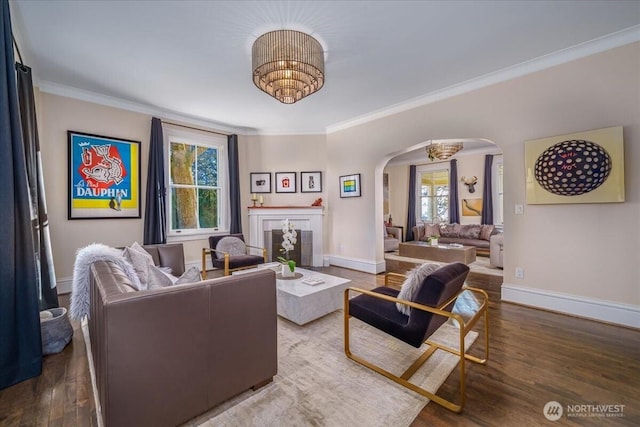 living room featuring crown molding, wood finished floors, and arched walkways