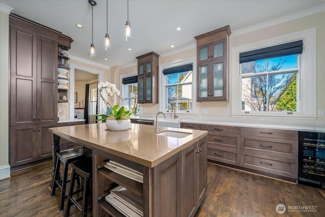 kitchen with a center island with sink, open shelves, a sink, light countertops, and wine cooler