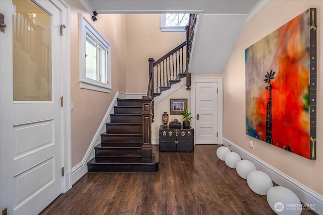 staircase featuring baseboards, wood finished floors, and ornamental molding