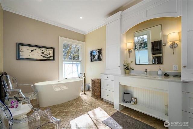 full bath featuring vanity, a soaking tub, recessed lighting, and ornamental molding