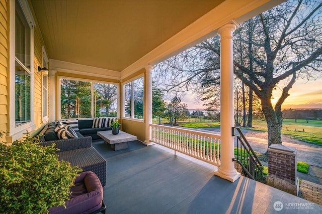 patio terrace at dusk with an outdoor hangout area and a porch