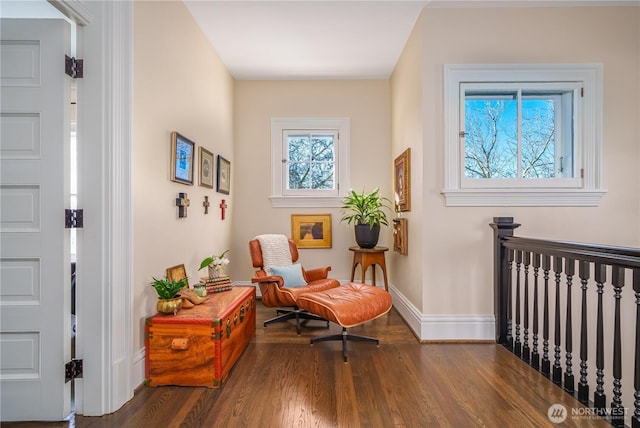 living area featuring baseboards and dark wood-style flooring