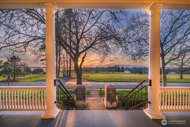 patio terrace at dusk featuring covered porch