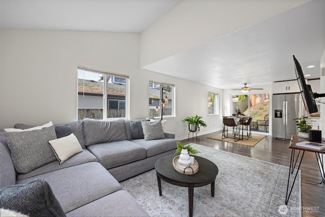 living room with ceiling fan, baseboards, wood finished floors, and vaulted ceiling