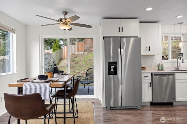 kitchen featuring dark wood-style flooring, white cabinets, appliances with stainless steel finishes, and a sink