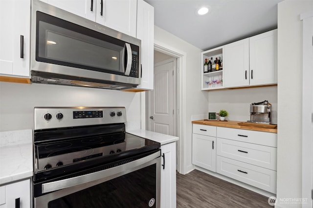 kitchen with light stone countertops, dark wood-style floors, white cabinets, stainless steel appliances, and open shelves