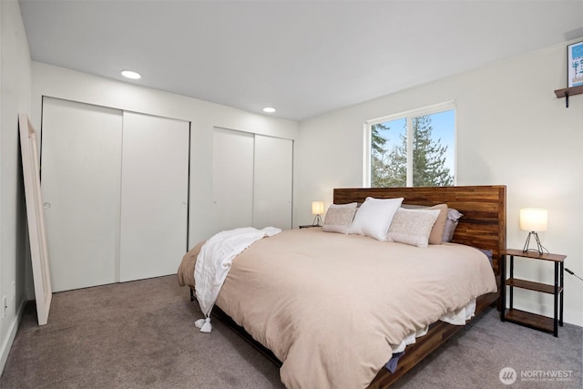 carpeted bedroom with recessed lighting and two closets