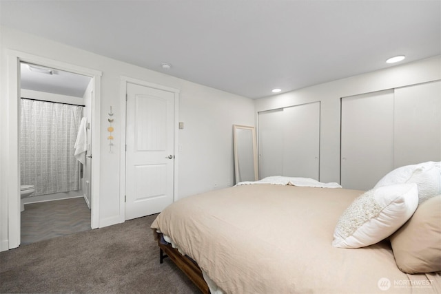 bedroom featuring recessed lighting, two closets, ensuite bath, and carpet flooring