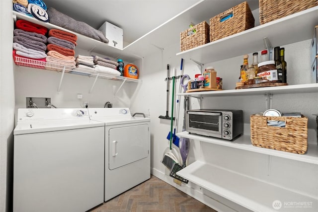 laundry room with washing machine and clothes dryer, laundry area, and a toaster