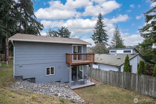 back of property featuring a lawn, a balcony, and fence