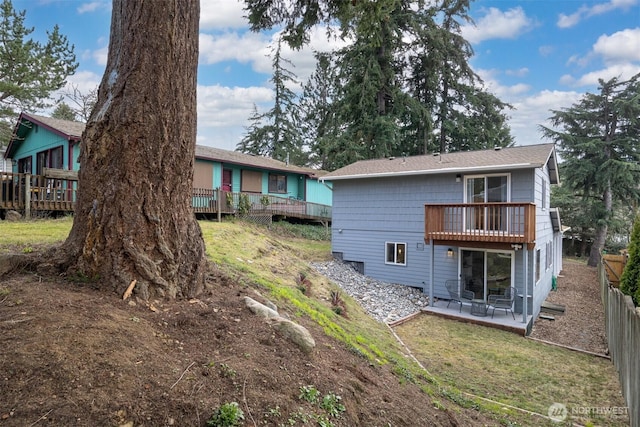 rear view of property featuring a patio, a yard, fence, and a wooden deck