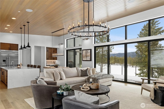 living room with recessed lighting, wooden ceiling, a high ceiling, light wood-style floors, and a mountain view