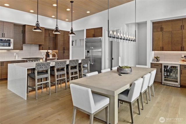 dining area featuring beverage cooler, recessed lighting, wooden ceiling, and light wood-type flooring