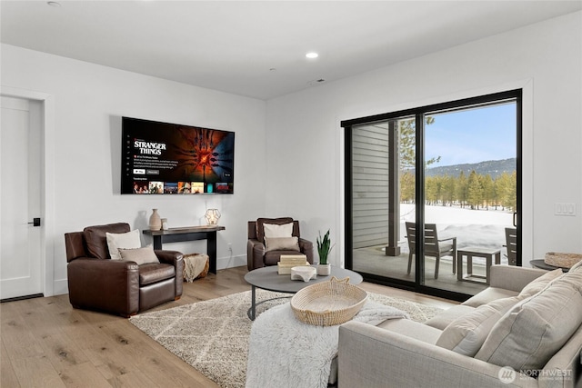 living room featuring recessed lighting, baseboards, and light wood-style floors