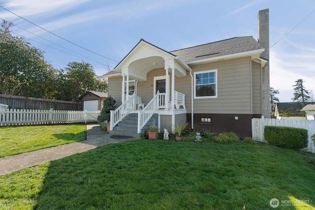 bungalow-style house with an outbuilding, a front lawn, a chimney, and fence