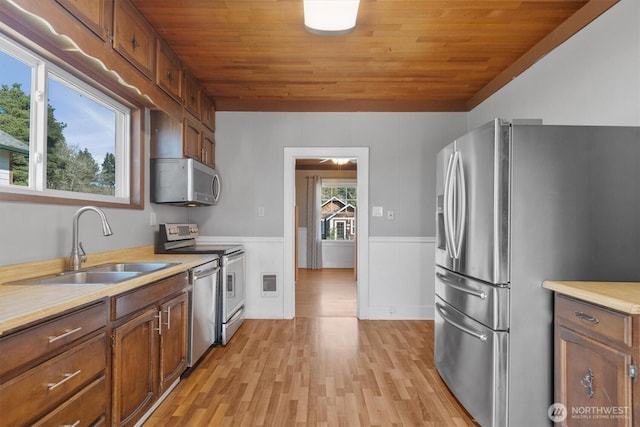 kitchen featuring appliances with stainless steel finishes, wooden ceiling, light countertops, and a sink