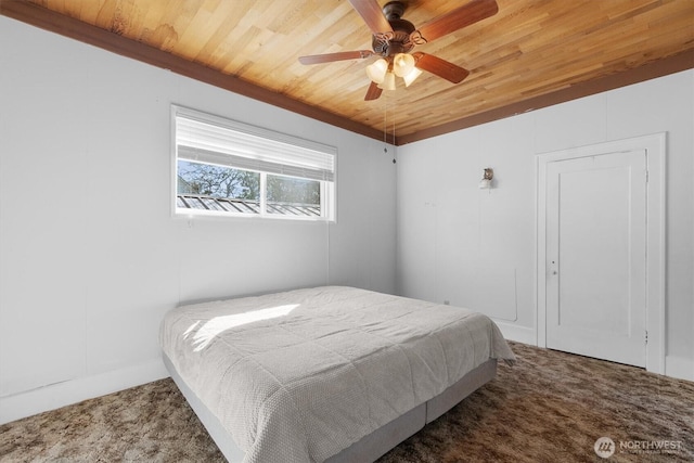 carpeted bedroom with wood ceiling and a ceiling fan