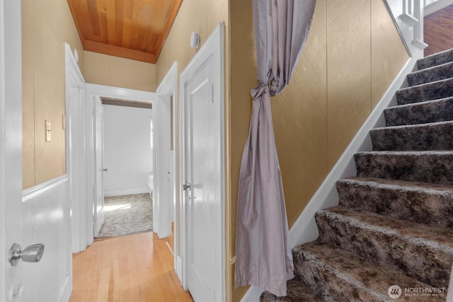 stairway featuring wooden ceiling and wood finished floors