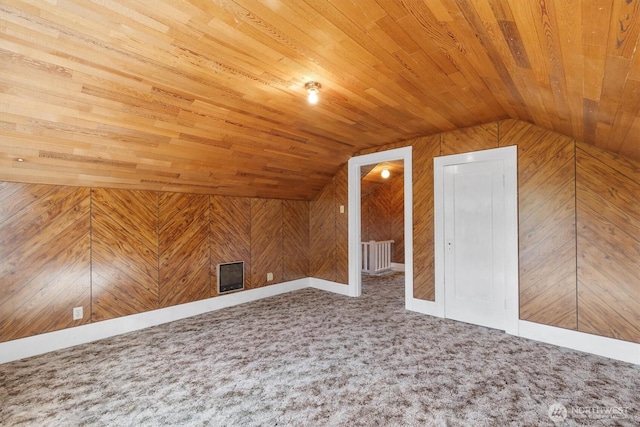 additional living space featuring carpet floors, wood walls, wooden ceiling, and vaulted ceiling