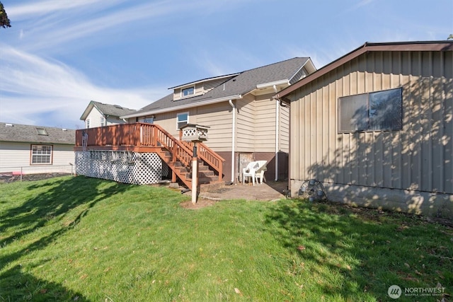 back of property with a lawn, a deck, and stairs